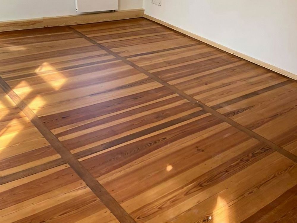 Ein Holzboden in einem Raum mit einem Fenster, das Tageslicht hereinlässt