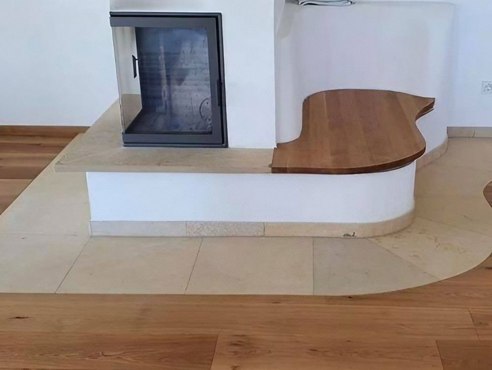 Eine Holzbank in einem Raum mit einem Kamin im Hintergrund im Vordergrund ist auch ein Holzboden zusehen